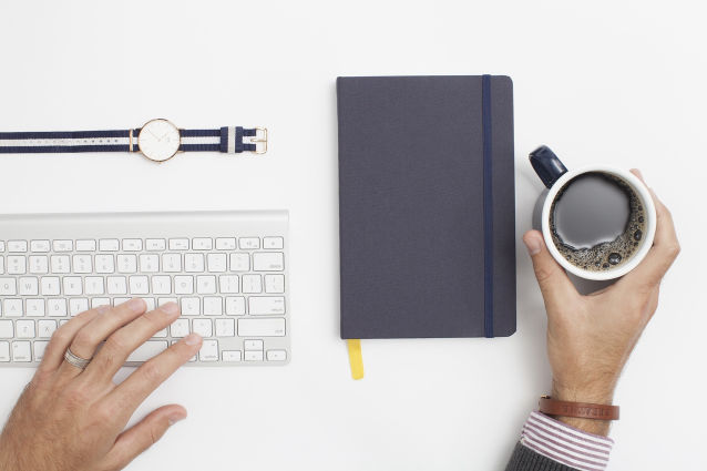 coffee cup beside computer