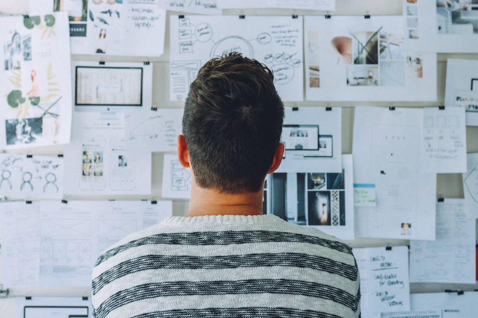 Man looking at papers tack to wall